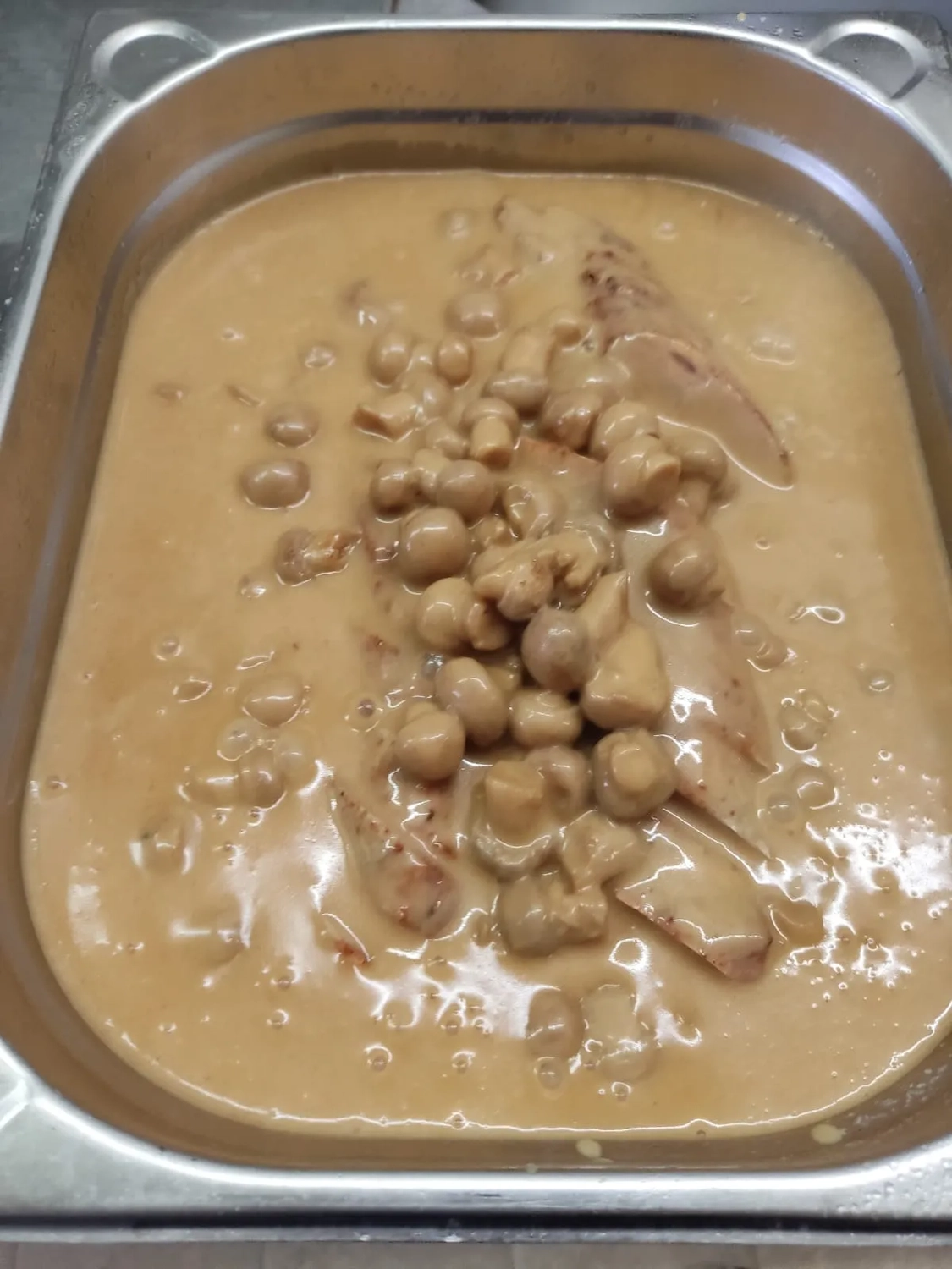 Thörnich – EventCatering – Das Gericht ähnelt einem Eintopf oder Curry mit einer cremigen, hellbraunen Sauce und Kichererbsen.